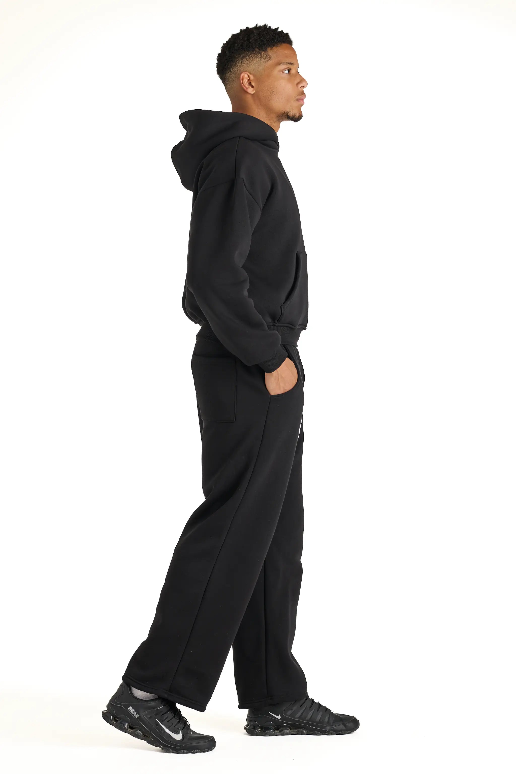 Modello che indossa una tuta intera nera Andrea Carducci, design boxy fit con dettagli minimal Made in Italy